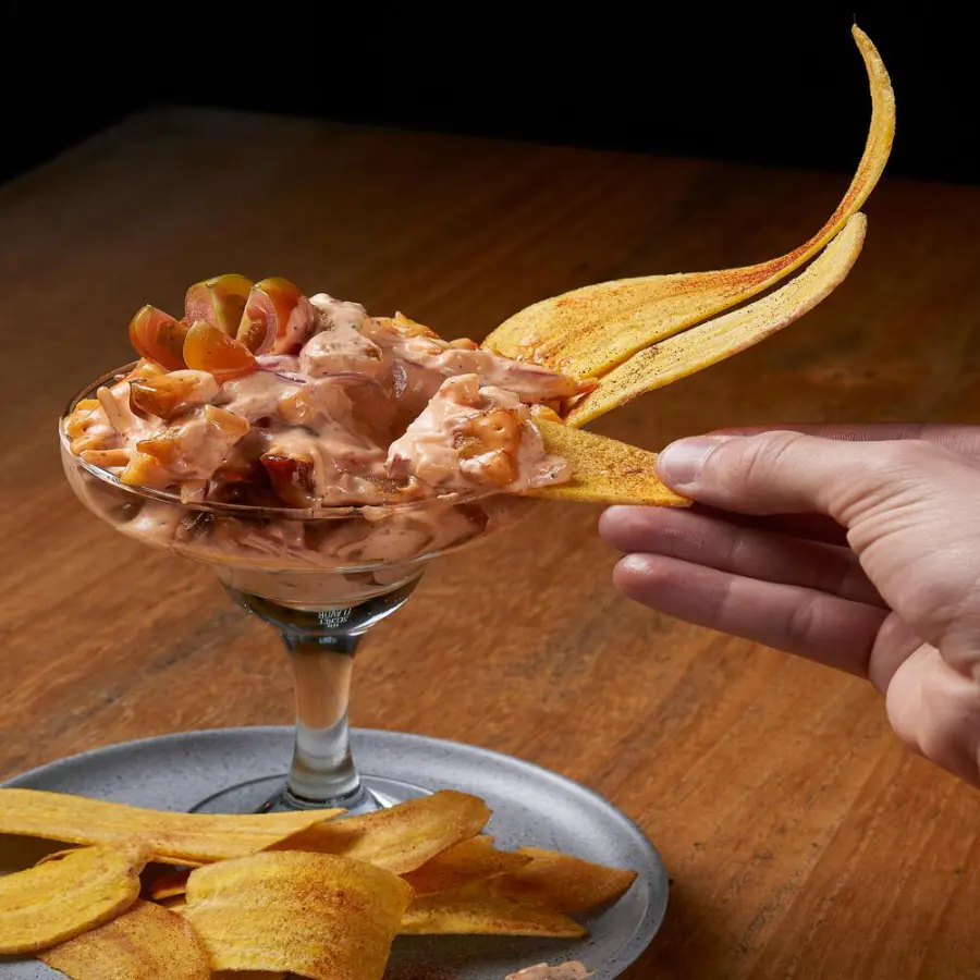 Ceviche de chicharrón servido en copa con chips de plátano