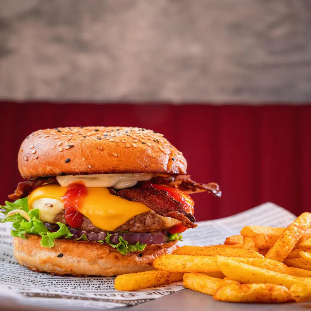Hamburguesa Bunker House con queso y tocineta, junto a papas
